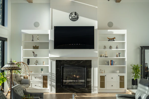 Example photo: a TV wall with fitted shelves and cupboards around a fireplace